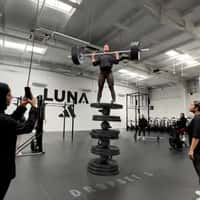 Adidas Woman Balancing on Piled Weight Plates