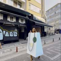 Reis Woman in Giant Shopping Bag