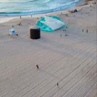 Who is Elijah Giant Inflated Perfume Bottle on Beach Shoreline