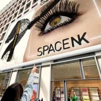 Space NK Giant Mascara Applied to Eye on Billboard