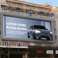 Volvo Car Driving Up to Billboard From Garage