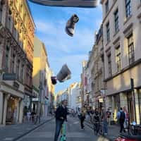 Coziness Giant Sneakers Float Above Cologne Street