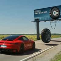 Mitas Giant Tire Passes Over Sports Car