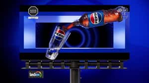 Bottle Fills Glass with Soda in a 3D Billboard Ad of Pepsi