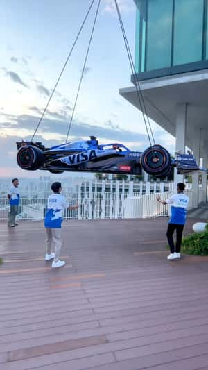 VISA F1 car lifted into a high-rise building fake-out-of-home ad of HUGO