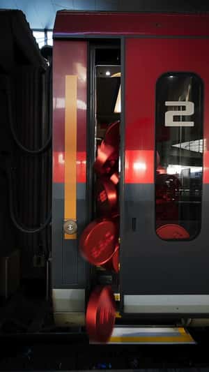 Red Coins Overflow at Train Station in a fake-out-of-home ad of ÖBB