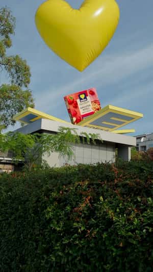 Cereal Carried by Yellow Heart Balloon in a fake-out-of-home ad of EDEKA