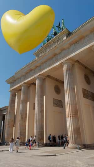 Yellow Heart Balloon Squeezes Out in a fake-out-of-home ad of EDEKA