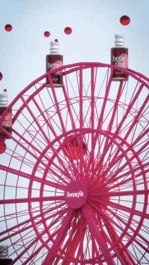 Lip Tint Wagons on Pink Ferris Wheel in a fake-out-of-home ad of Benefit Cosmetics