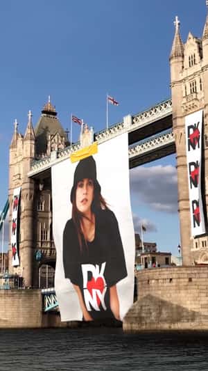 Model’s Poster Rolls Down on Bridge in a fake-out-of-home ad of DKNY