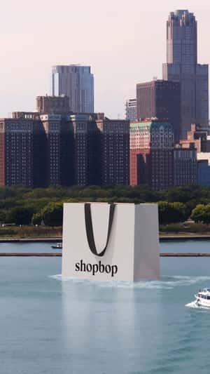 Shopping Bag Cruising on River in a fake-out-of-home ad of Shopbop