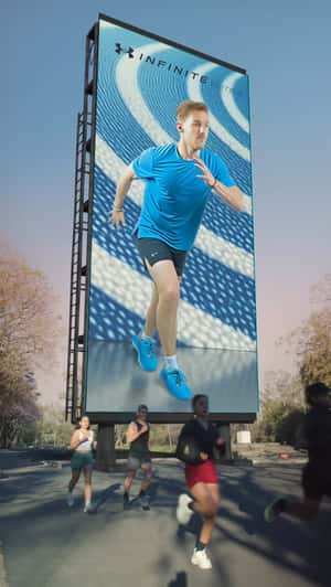 Runner Comes Out From Billboard in a fake-out-of-home ad of Under Armour