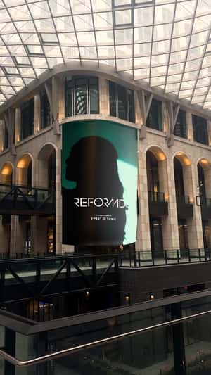 Banner Rolls Inside Shopping Center in a fake-out-of-home ad of Reformd