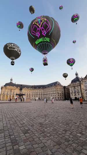 Hot Air Balloons Glide Above Paris in a fake-out-of-home ad of Madame Loyal Festival