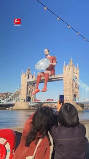 Giant Player Sits on the Bridge in a fake-out-of-home ad of Bundesliga
