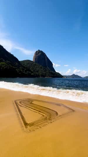 Logo Formed by Waves on Sand in a fake-out-of-home ad of Superman