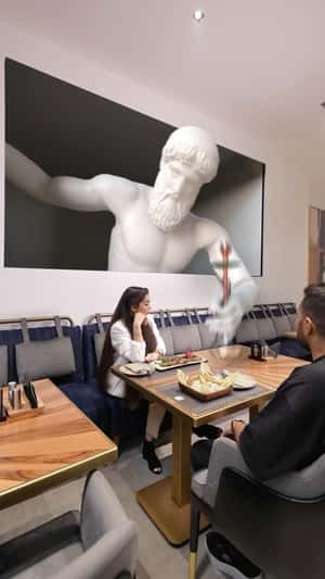 Statue Hands Hookah on Table in a fake-out-of-home ad of Aseel Restaurant