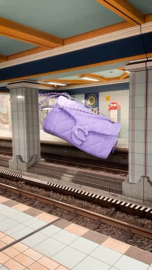 Shoulder Bag Floats Above Railway in a fake-out-of-home ad of Coach