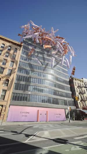 Lip Gloss Rain Down From Building in a fake-out-of-home ad of Lancôme