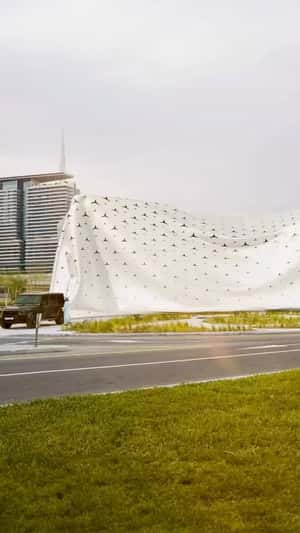 Car Pulls Cloth to Unveil Building in a fake-out-of-home ad of Mercedes-Benz