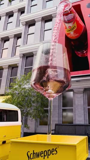 Bottle Pours into Glass on Wagon in a fake-out-of-home ad of Schweppes