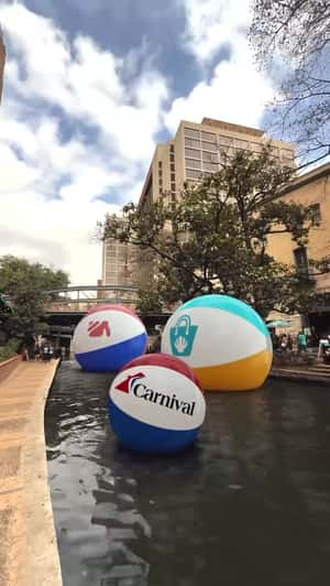 Beach Balls Float at River Walk in a fake-out-of-home ad of Carnival Cruise Lines