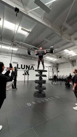 Woman Balancing on Piled Weight Plates in a fake-out-of-home ad of Adidas