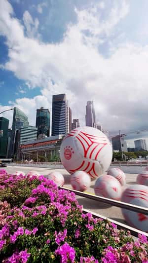 Footballs Roll Through Singapore's Landmarks in a fake-out-of-home ad of Adidas