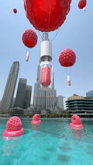 Lip Oils on Raspberry Hot Air Balloons in a fake-out-of-home ad of Lifestyle