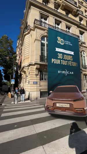 Car Emerges from Rolled-Down Billboard in a fake-out-of-home ad of BYmyCAR