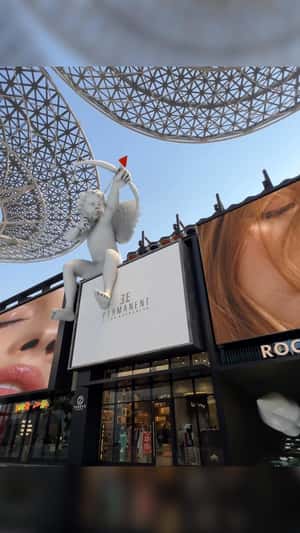 Cupid Shooting Arrows on Inflatable Lips in a fake-out-of-home ad of Elle Permanent
