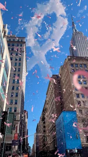 Pink Ribbons Falling Over NYC in a fake-out-of-home ad of Flo Health App