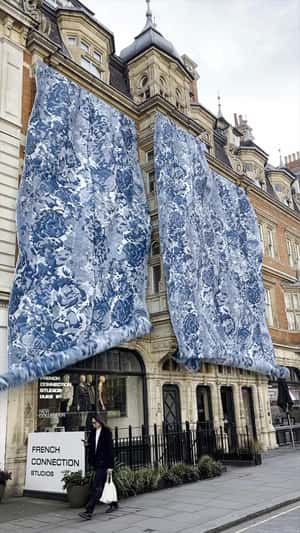 Fabric Rolls Down on Building in a fake-out-of-home ad of French Connection