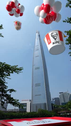 Chicken Bucket Lands with Balloons in a fake-out-of-home ad of KFC