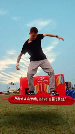 Man Surfs on Chocolate Bar in a fake-out-of-home ad of KitKat