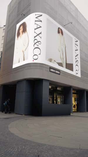 Digital Screen Spills Christmas Balls in a fake-out-of-home ad of MAX& Co.
