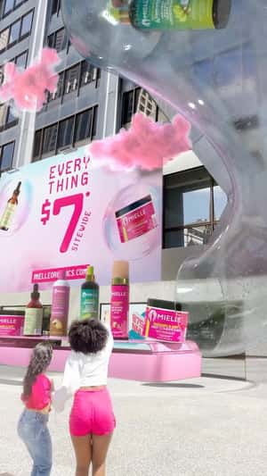 Products Slide Up from Conveyor in a fake-out-of-home ad of Mielle Organics