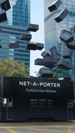 Double-decker Bus Unloads Black Boxes in a fake-out-of-home ad of NET-A-PORTER
