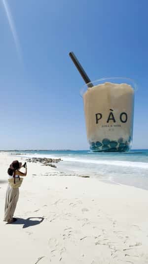 Two Giant Bubble Teas Tower Over Beach in a fake-out-of-home ad of PÀO