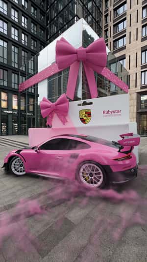 Pink Car Drives Out a Giant Box in a fake-out-of-home ad of Porsche