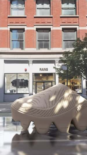 Giant Zip Mule Shoes Glide Through Water by Storefront in a fake-out-of-home ad of Rains