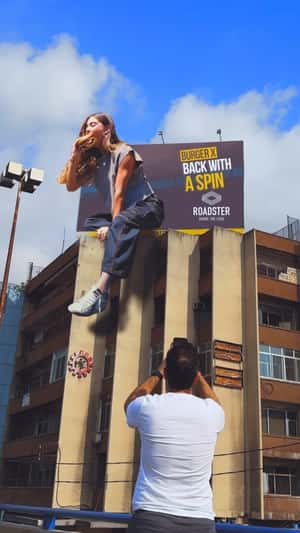 Woman Steps Out of Billboard in a fake-out-of-home ad of Roadster Diner