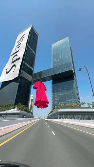 Red Dress Hangs in Dubai Gate Towers in a fake-out-of-home ad of Splash Fashions