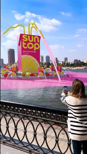 Pink Lemonade Fountain Colors Waterfront in a fake-out-of-home ad of Sunto