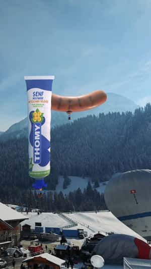 Giant Mustard Tube and Hotdog Over Swiss Alps in a fake-out-of-home ad of Thomy