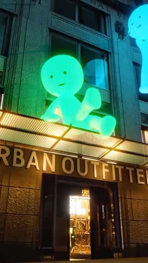 Glowing Smiskis Take Over Storefront in a fake-out-of-home ad of Urban Outfitters