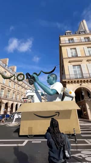 Zlu Emerges From Giant Box in Paris in a fake-out-of-home ad of Amazon