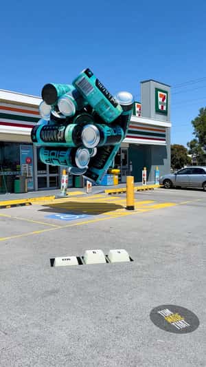 Giant Cans Cluster in Front of 7-Eleven in a fake-out-of-home ad of Flipside Energy