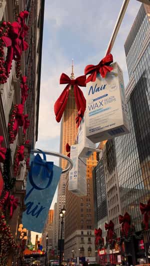 Giant Products and Shopping Bags Hang in Times Square in a fake-out-of-home ad of Nair