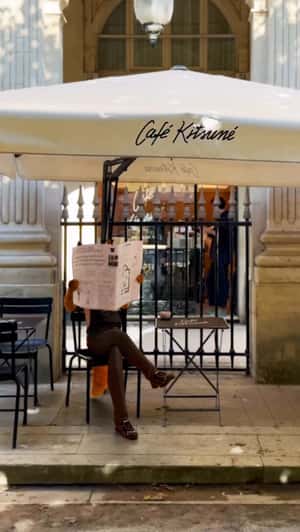 Barista Fox Reads Newspaper in a fake-out-of-home ad of Café Kitsuné